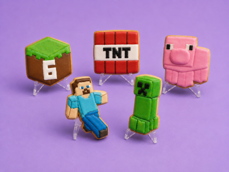 Minecraft themed decorated cookies standing on clear stands with purple background