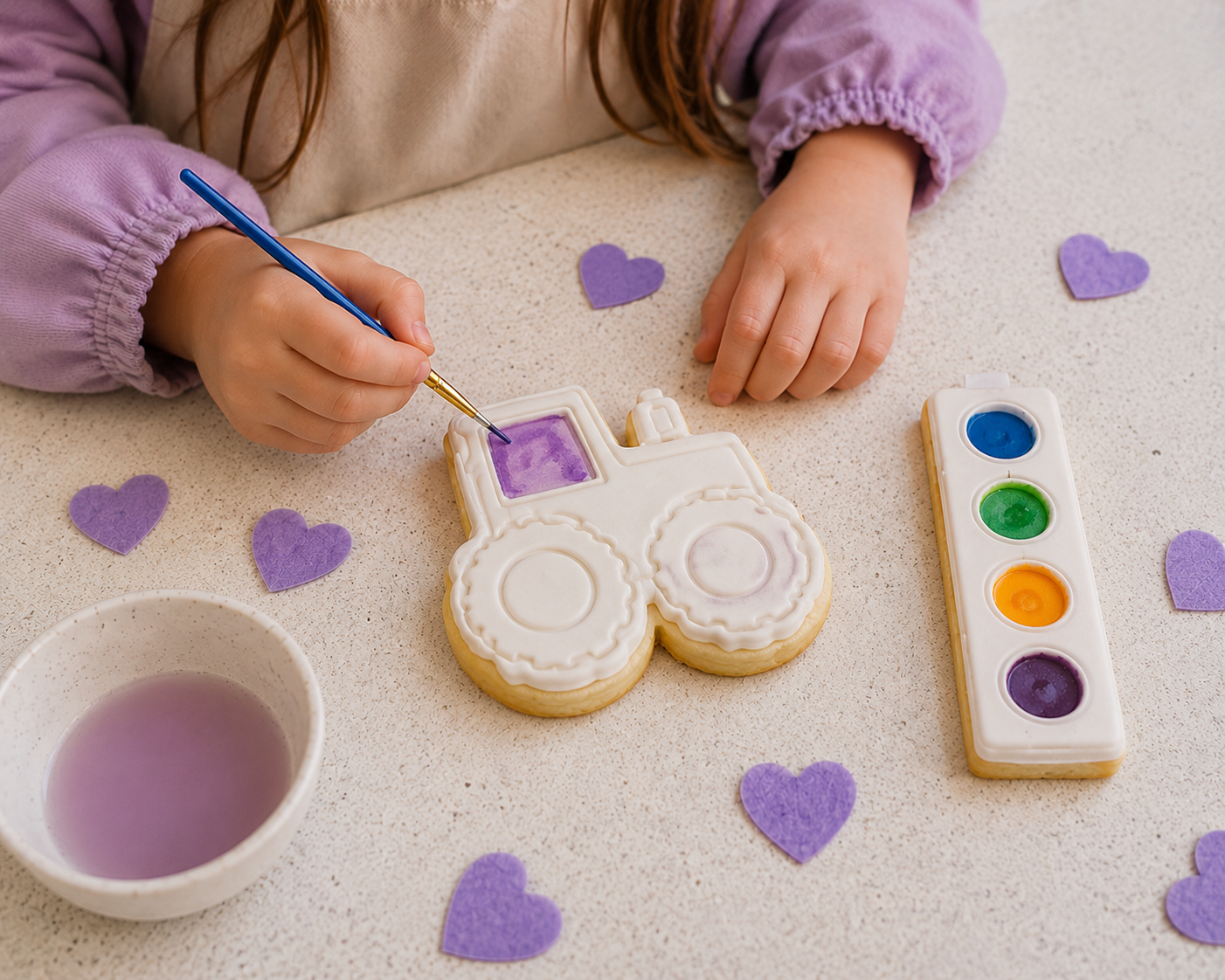 Child painting a paint your own tractor cookie with four colour edible palette