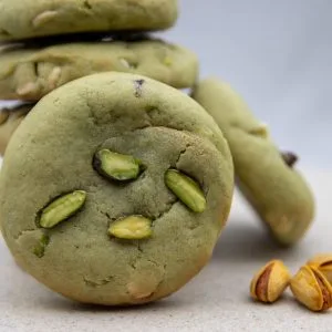 A stack of Stuffed Pistachio Bliss Bites, with the cookies’ vibrant green pistachio colour and toppings visible.