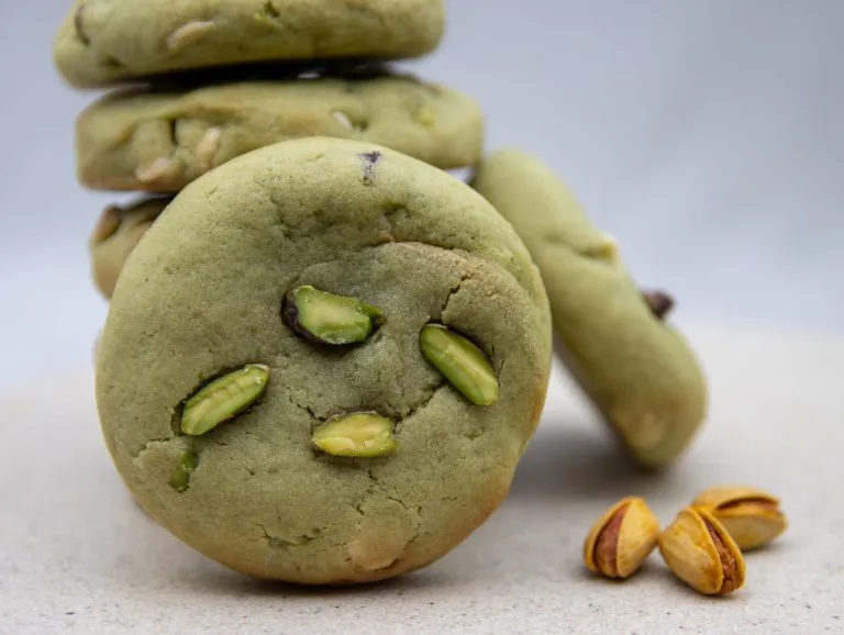 A stack of Stuffed Pistachio Bliss Bites, with the cookies’ vibrant green pistachio colour and toppings visible.