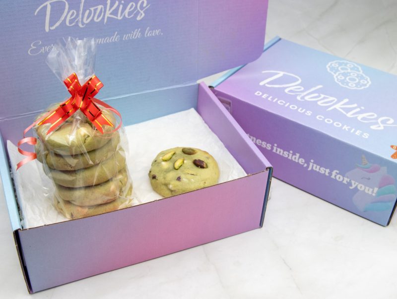 A neat arrangement of Stuffed Pistachio Bliss Bites in a beautiful premium packaging, highlighting the pistachio pieces and smooth, creamy filling inside.