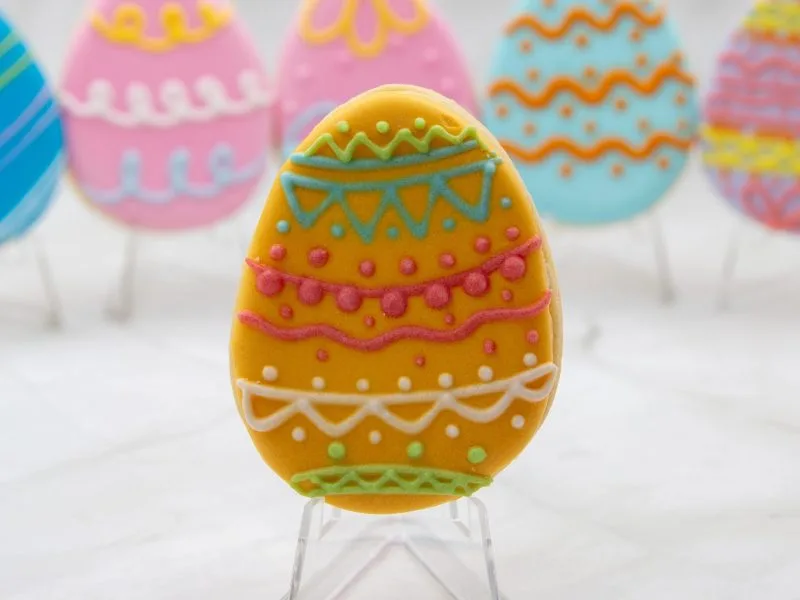 Close-up of an individual Easter Egg Wonderland Cookie featuring yellow icing with geometric patterns.