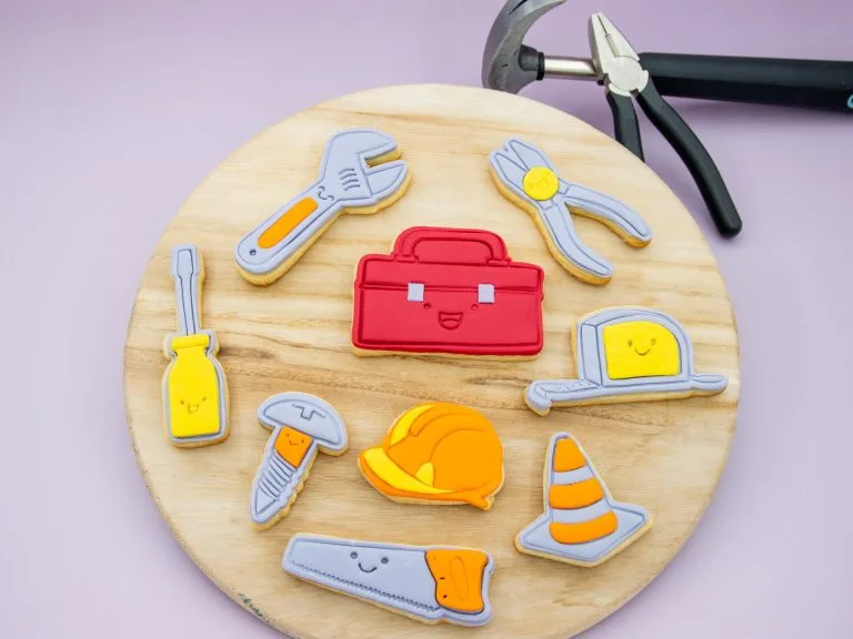 Builder-themed fondant cookies styled with toy tools and birthday decor