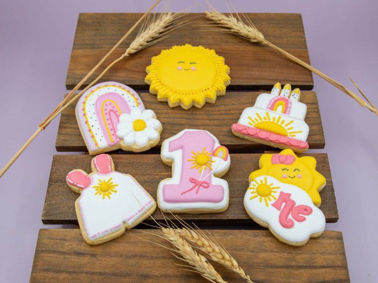 Sunshine birthday cookies styled for girl’s first party with soft props