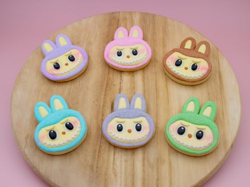 Pastel Labubu face cookies styled with props on pink background