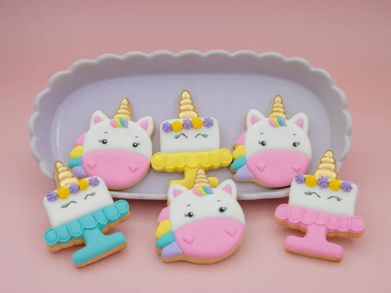 Unicorn cookies styled with pastel props on pink background