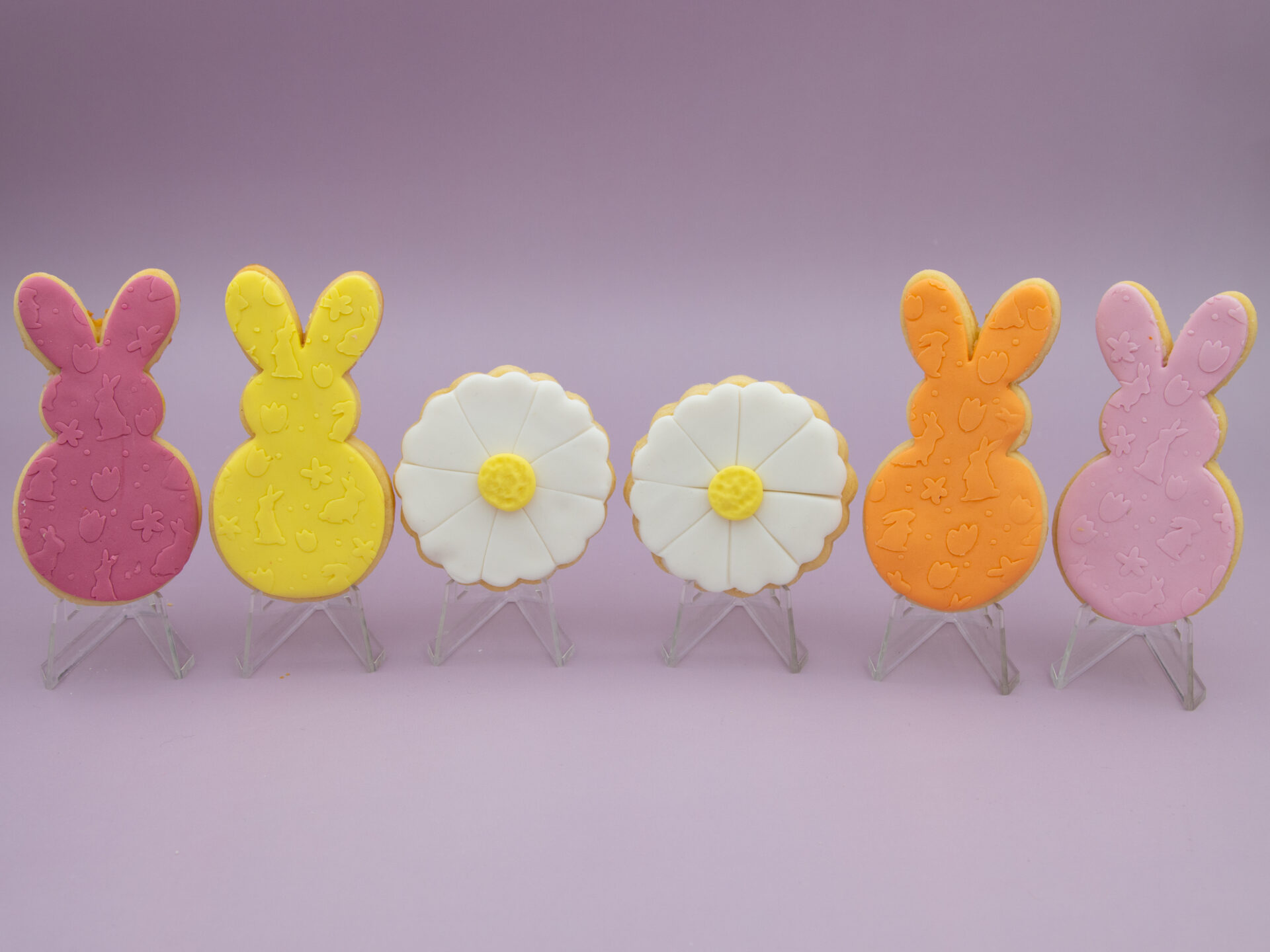 Pastel Bunny & Daisy Easter Cookies standing side by side with pastel bunny and daisy fondant designs