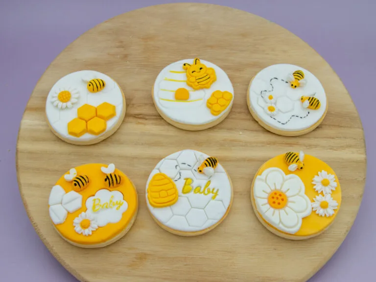 What Will It Bee Baby Cookies styled for a baby shower with fondant bee daisy and honeycomb designs