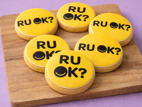 R U OK? Awareness Cookies styled in a bright yellow edible print fondant set for workplace wellbeing events