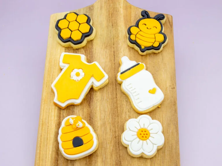 Honey Bee Baby Cookies styled for a baby shower with bee and daisy themed props