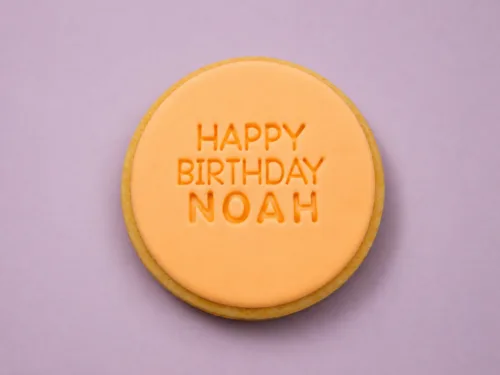 Flat lay personalised birthday cookies with custom name embossing on fondant