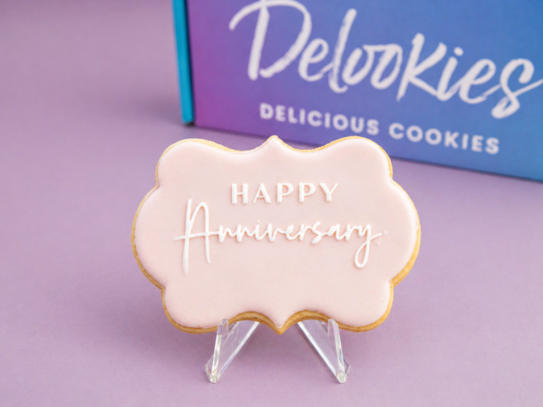 Close up happy anniversary cookie with scalloped fondant shape and raised white lettering