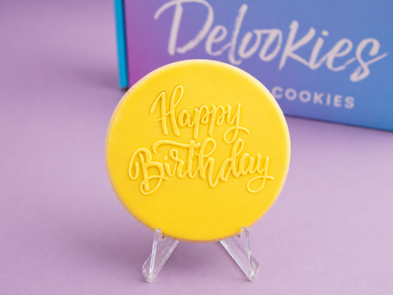 Close up happy birthday cookie with embossed script on fondant