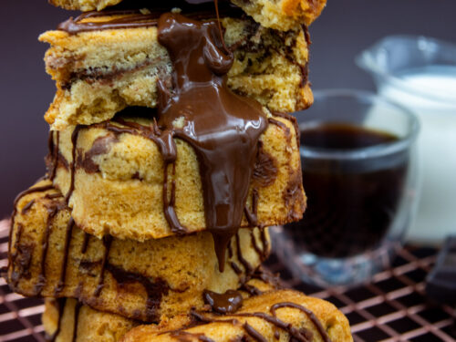 Stacked Chocolate Chip Cookie Cubes with melted chocolate sauce pouring over the cookies