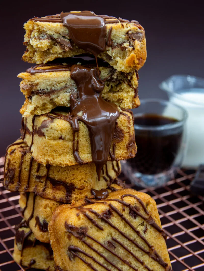 Stacked Chocolate Chip Cookie Cubes with melted chocolate sauce pouring over the cookies